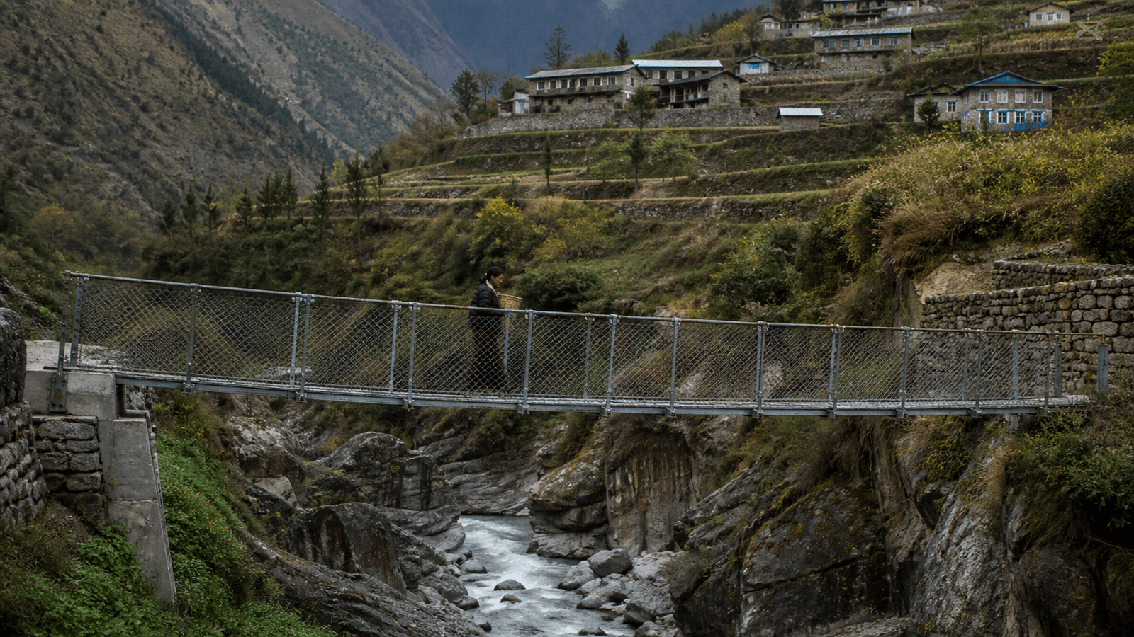 A suspended footbridge crossing a narrow gorge, with a figure walking across